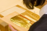 Observe up close how the artisan transfers the goldleaf.